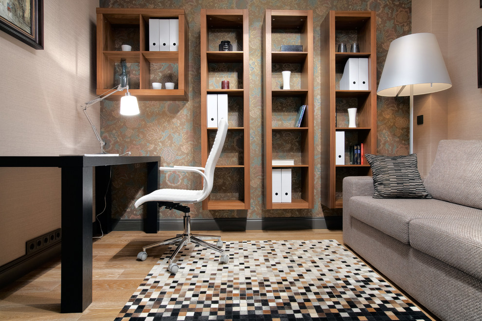 Diseño de despacho actual de tamaño medio con escritorio independiente, paredes beige y suelo de madera clara