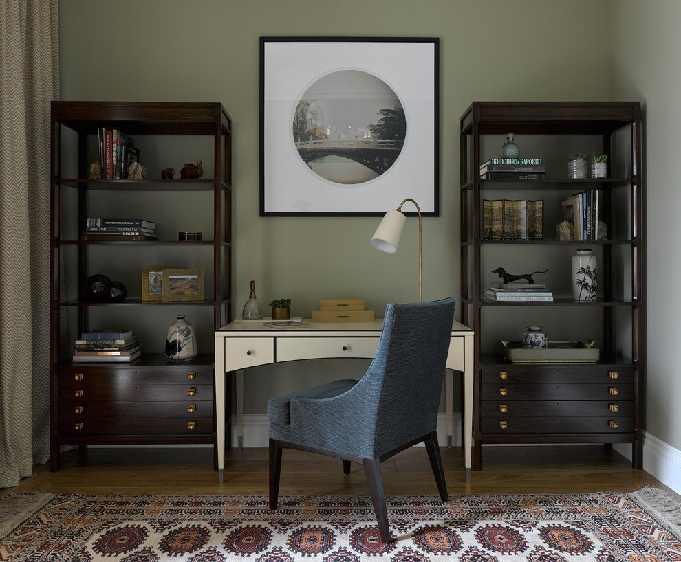 Ejemplo de despacho tradicional renovado de tamaño medio sin chimenea con paredes verdes, suelo de madera en tonos medios y escritorio independiente