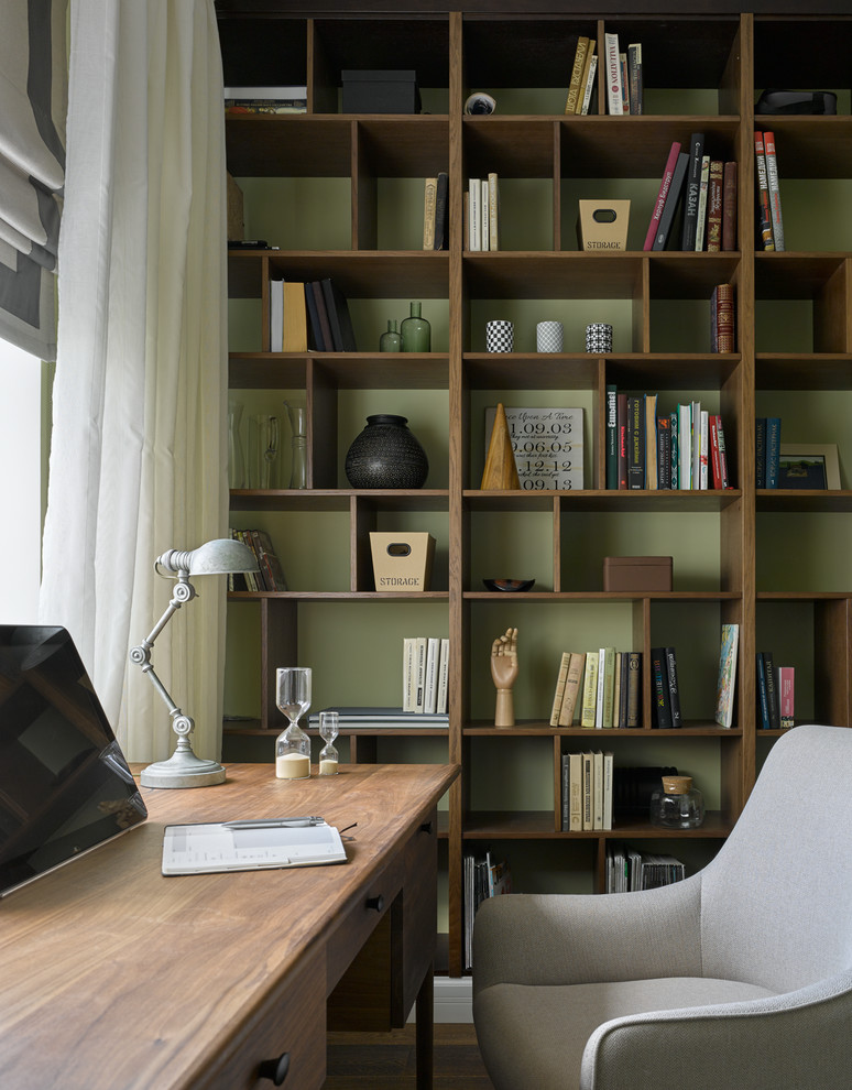 На фото: рабочее место в стиле неоклассика (современная классика) с зелеными стенами и отдельно стоящим рабочим столом с