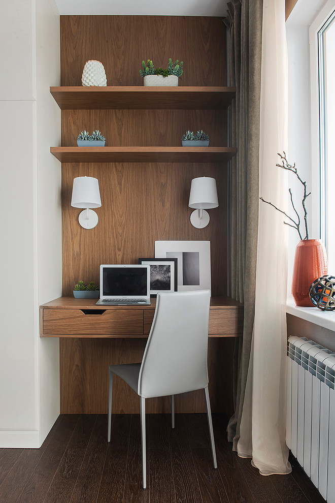 Imagen de despacho actual con suelo de madera oscura, escritorio empotrado, suelo marrón y paredes marrones