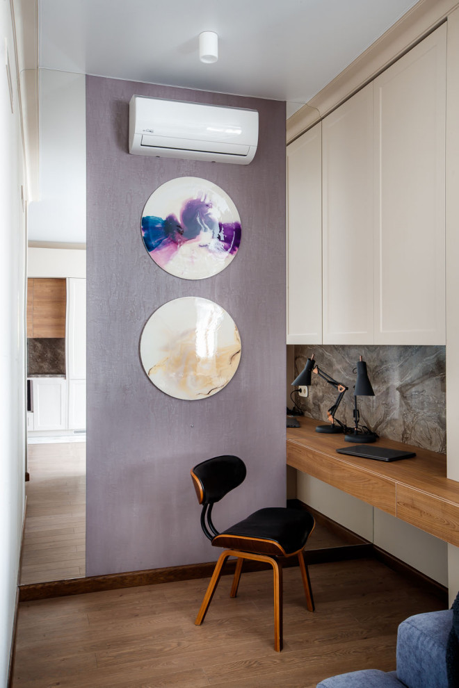 Источник вдохновения для домашнего уюта: рабочее место в современном стиле с фиолетовыми стенами, встроенным рабочим столом, паркетным полом среднего тона и коричневым полом