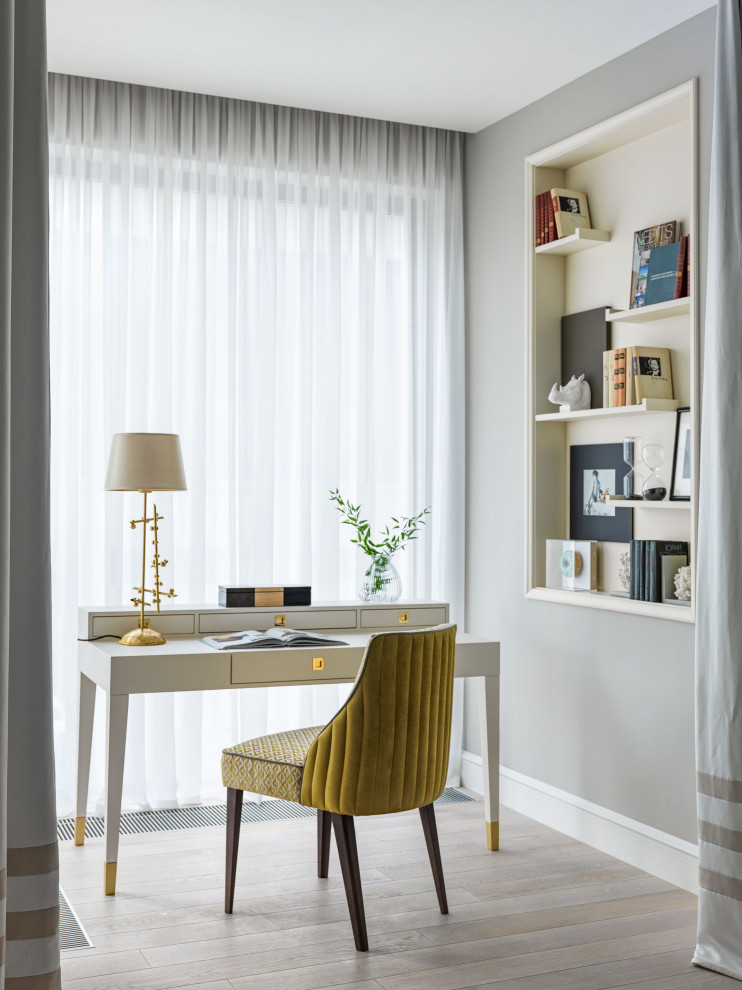 Diseño de despacho clásico renovado de tamaño medio con paredes grises, suelo de madera clara, escritorio independiente y suelo beige
