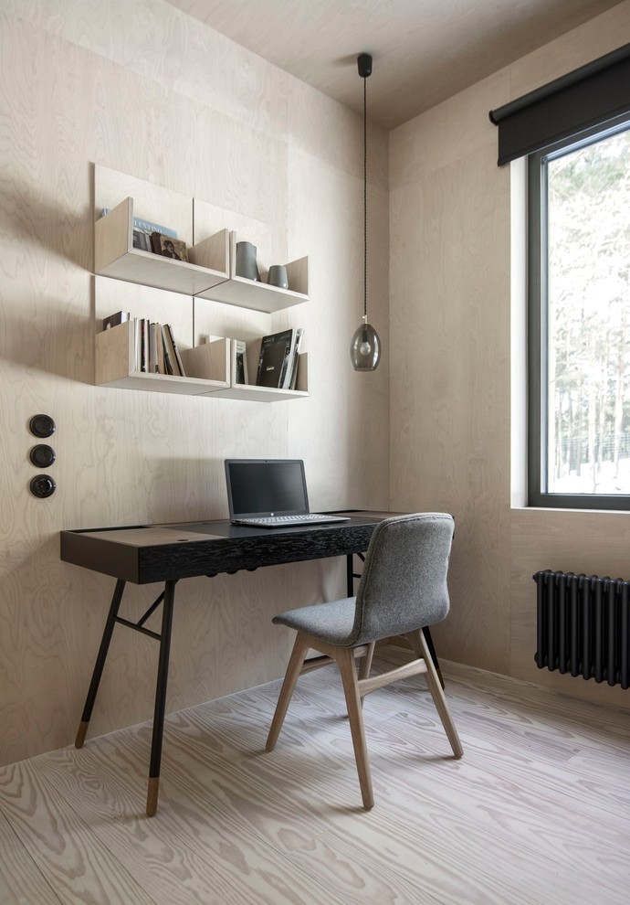 Imagen de despacho nórdico pequeño sin chimenea con biblioteca, escritorio independiente y suelo de madera clara
