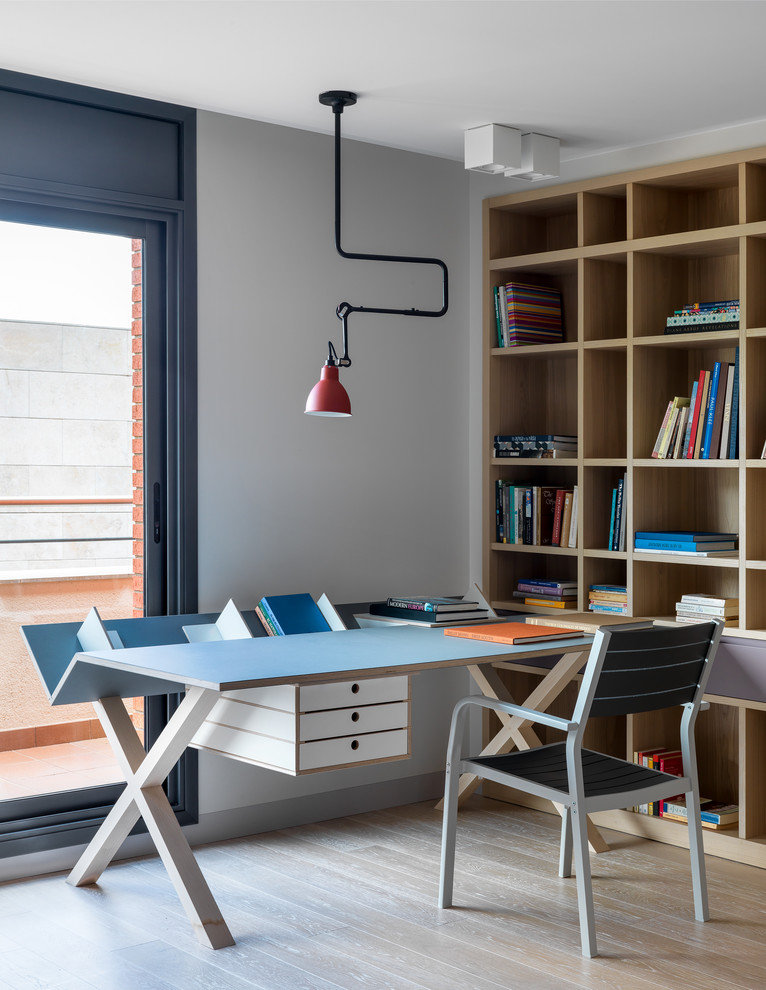 Immagine di uno studio design con pareti bianche, parquet chiaro, scrivania autoportante e pavimento beige