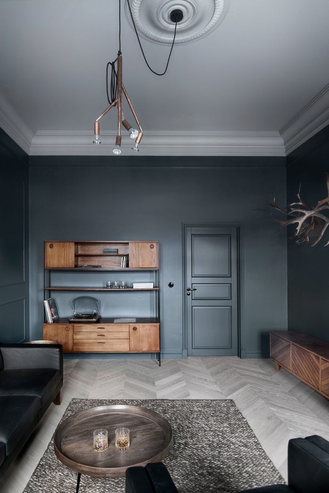 Esempio di un grande studio design con libreria, pareti blu, parquet chiaro e pavimento grigio
