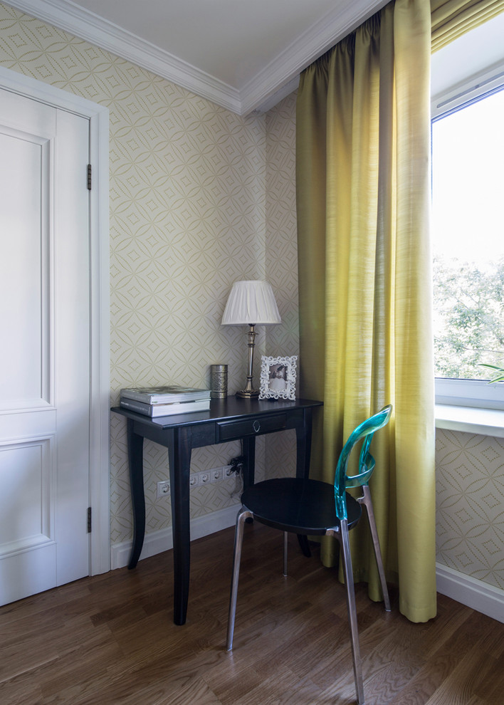 Diseño de despacho contemporáneo con paredes beige, suelo de madera en tonos medios y escritorio independiente