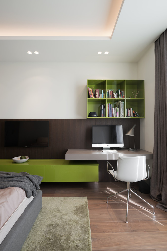 Foto de despacho actual con paredes blancas, suelo de madera en tonos medios, escritorio empotrado y suelo marrón