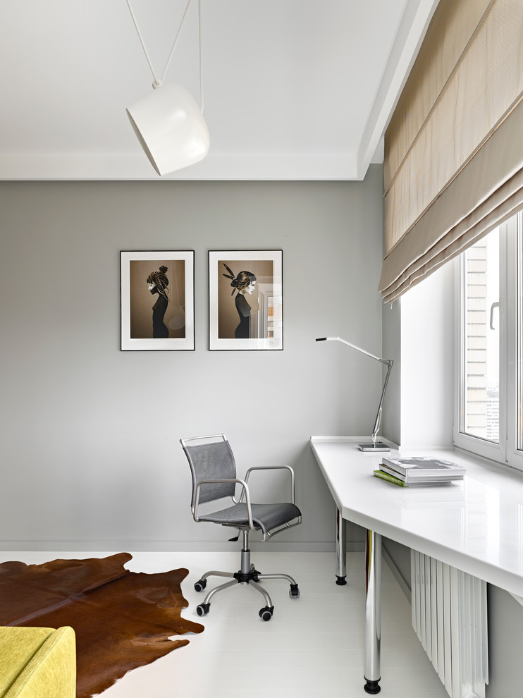 Modernes Arbeitszimmer mit Arbeitsplatz, grauer Wandfarbe, hellem Holzboden und Einbau-Schreibtisch in Moskau