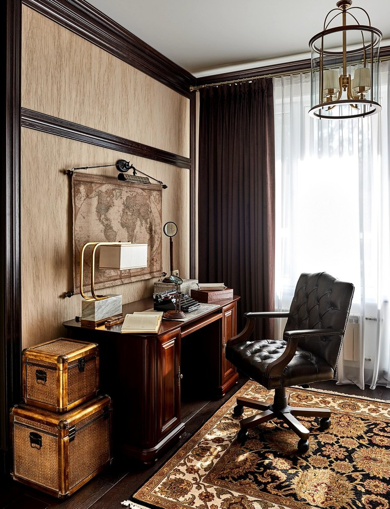 Imagen de despacho clásico de tamaño medio con paredes beige, suelo de madera oscura y escritorio independiente