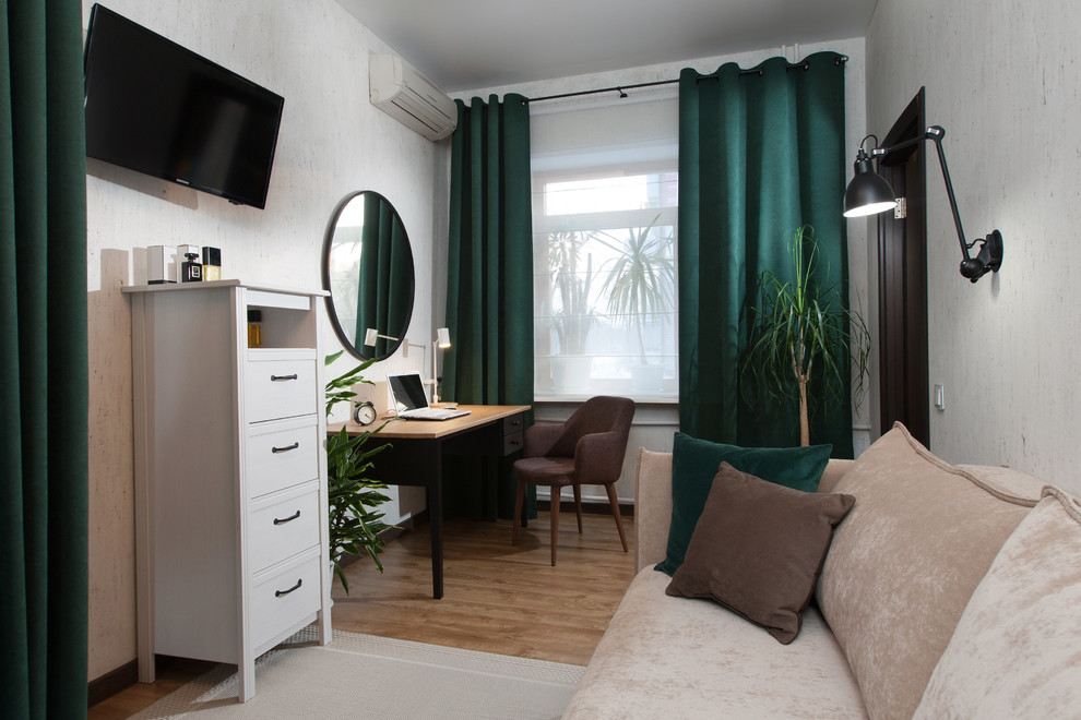 Стильный дизайн: рабочее место в скандинавском стиле с белыми стенами, полом из ламината, отдельно стоящим рабочим столом и коричневым полом - последний тренд