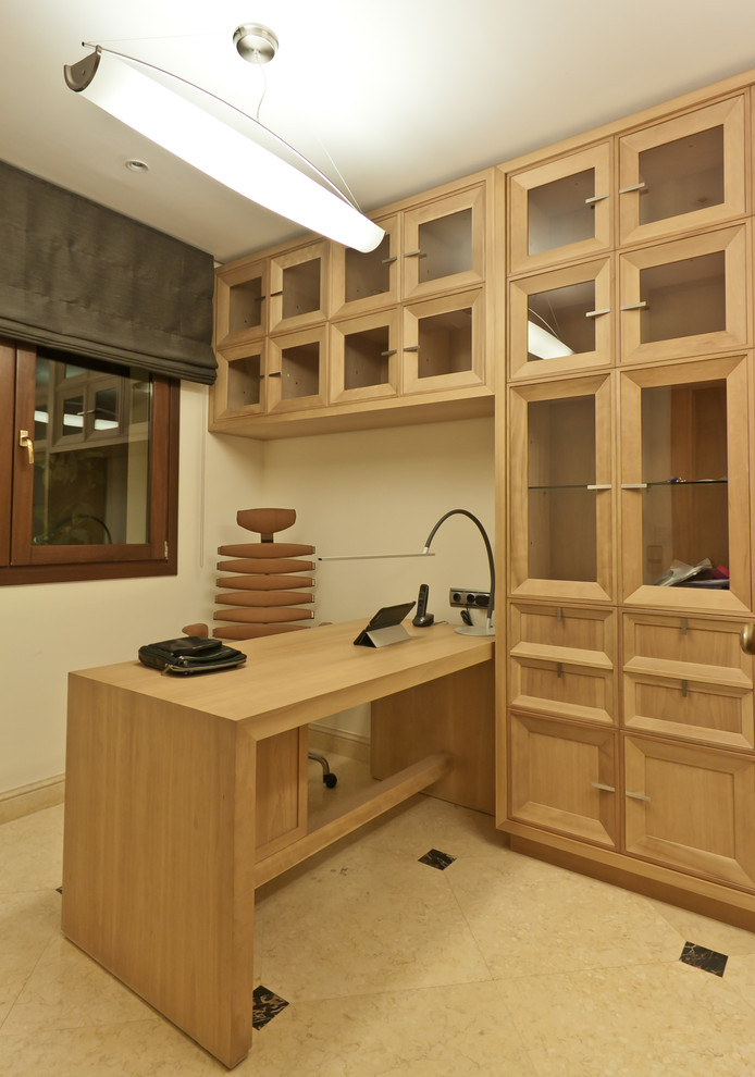 Ejemplo de despacho mediterráneo pequeño con paredes beige, suelo de mármol y escritorio independiente