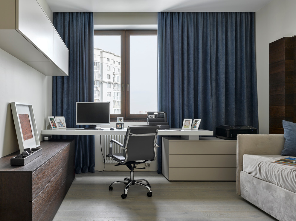Стильный дизайн: рабочее место в современном стиле с белыми стенами, светлым паркетным полом и встроенным рабочим столом без камина - последний тренд