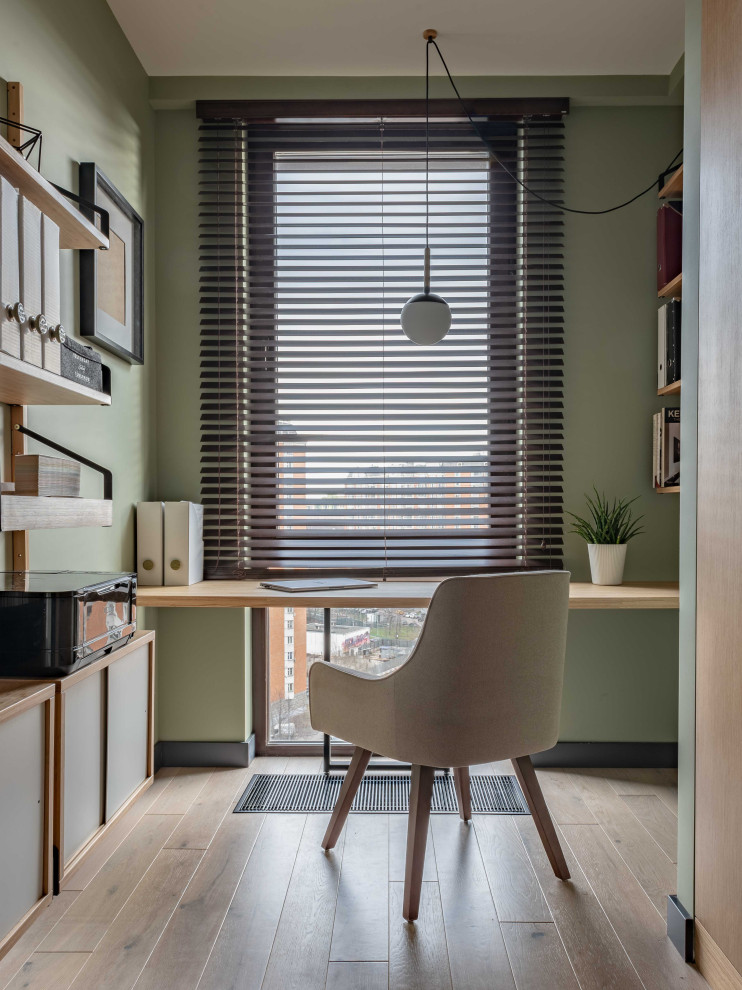 Immagine di un ufficio scandinavo di medie dimensioni con pareti verdi, pavimento in legno massello medio e scrivania incassata