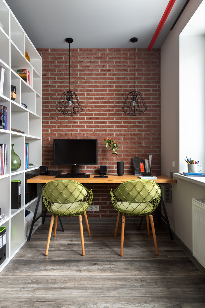 Esempio di un piccolo ufficio contemporaneo con pavimento in laminato, scrivania autoportante, pareti rosse e nessun camino
