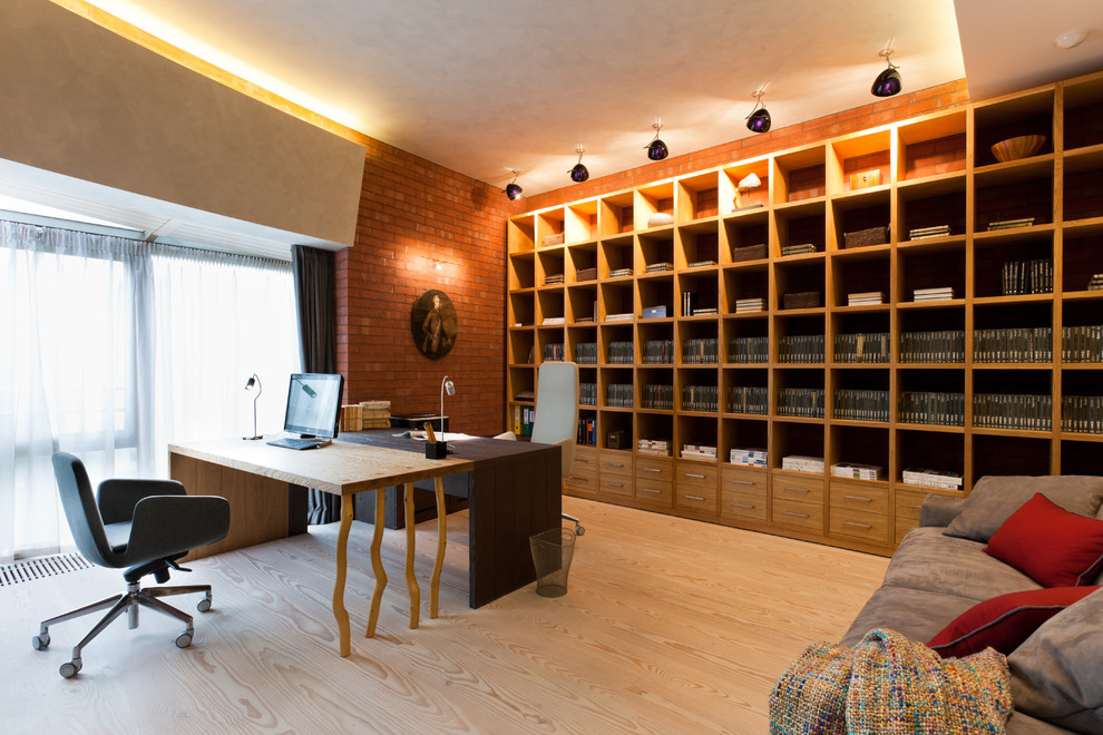 Immagine di un ufficio design con parquet chiaro e scrivania autoportante