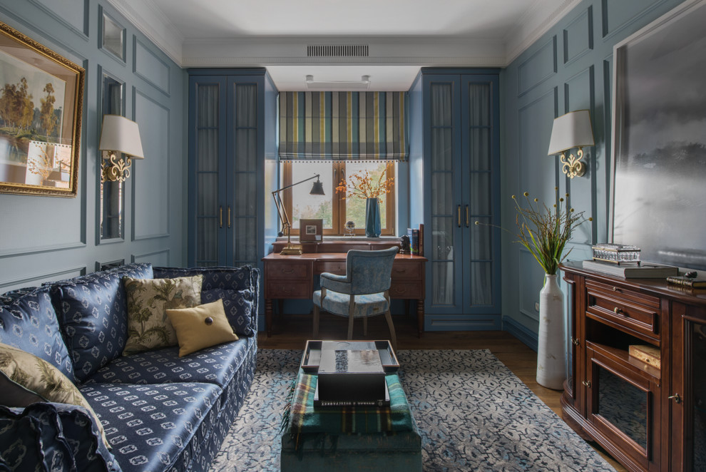 Diseño de despacho tradicional renovado de tamaño medio con paredes azules, suelo de madera en tonos medios, escritorio independiente y suelo marrón