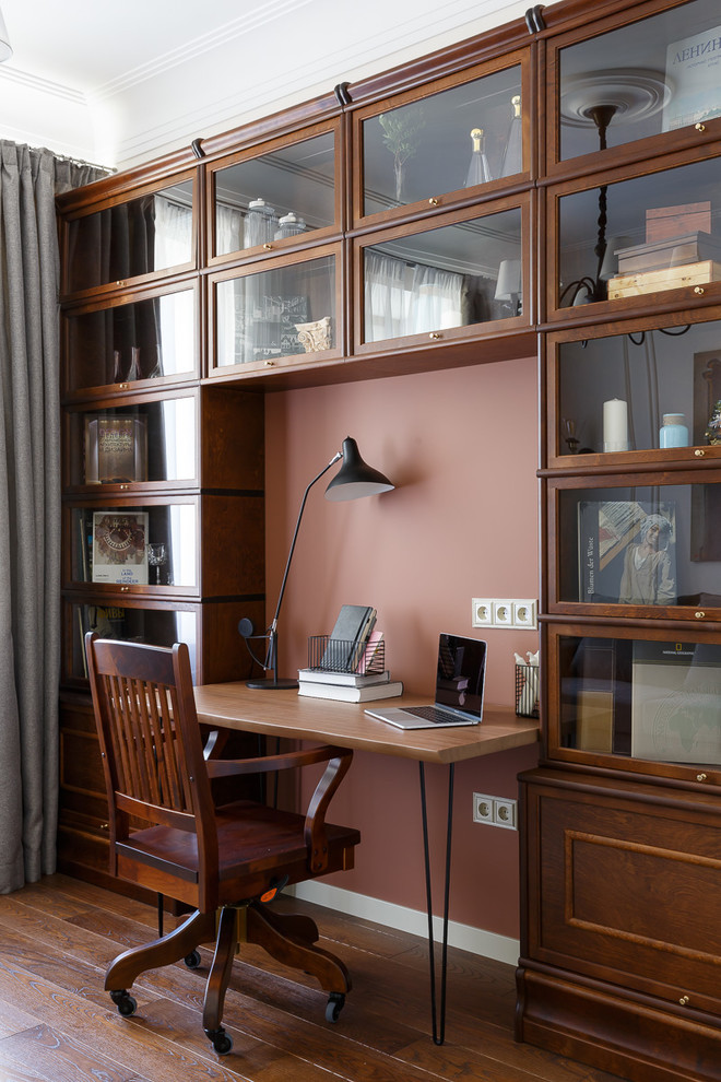 Klassisk inredning av ett hemmabibliotek, med bruna väggar, mörkt trägolv, ett fristående skrivbord och brunt golv