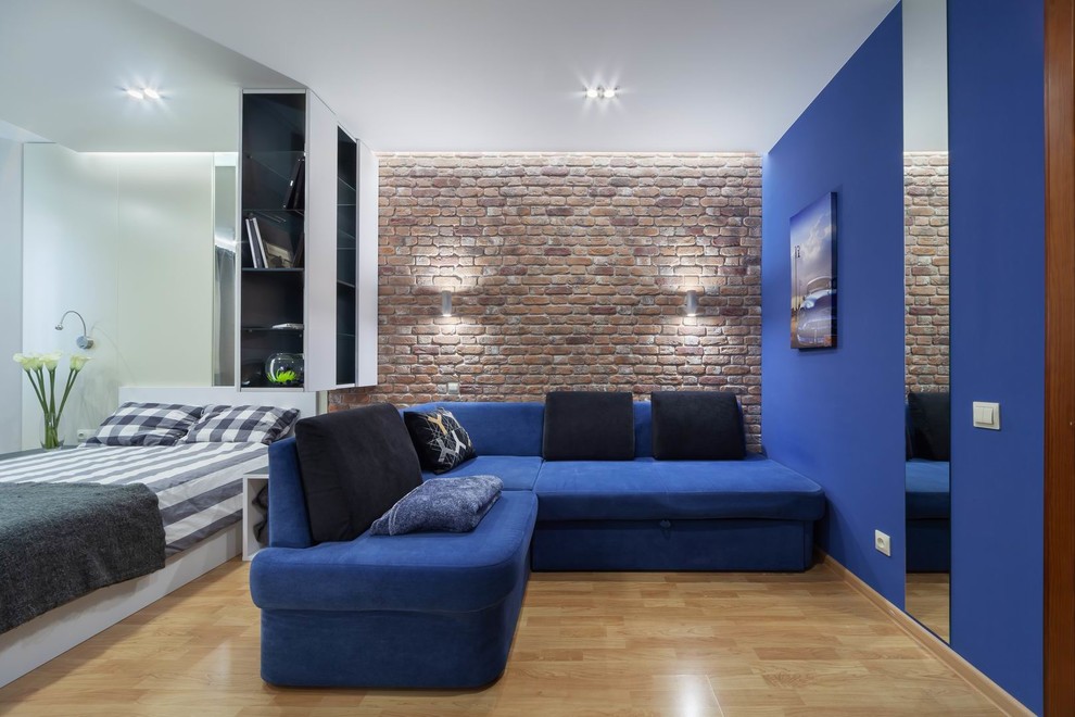 Inspiration för stora industriella arbetsrum, med blå väggar, laminatgolv och ett inbyggt skrivbord