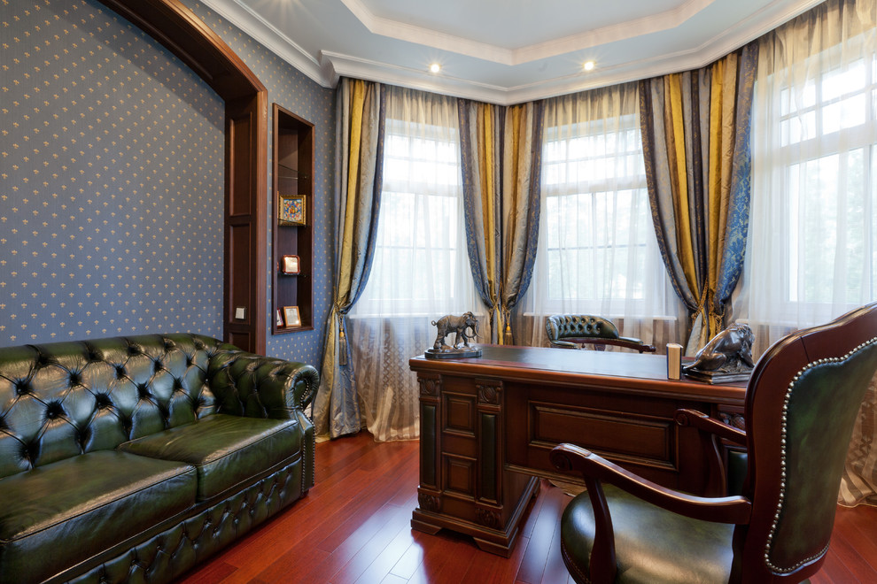 Modelo de despacho clásico de tamaño medio con paredes azules, escritorio independiente y suelo de madera oscura