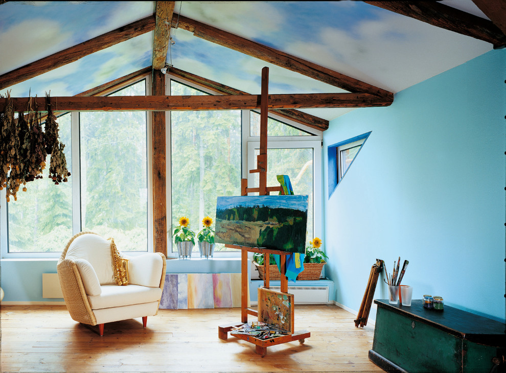 Foto på ett mellanstort eklektiskt hemmastudio, med ljust trägolv, blå väggar och brunt golv