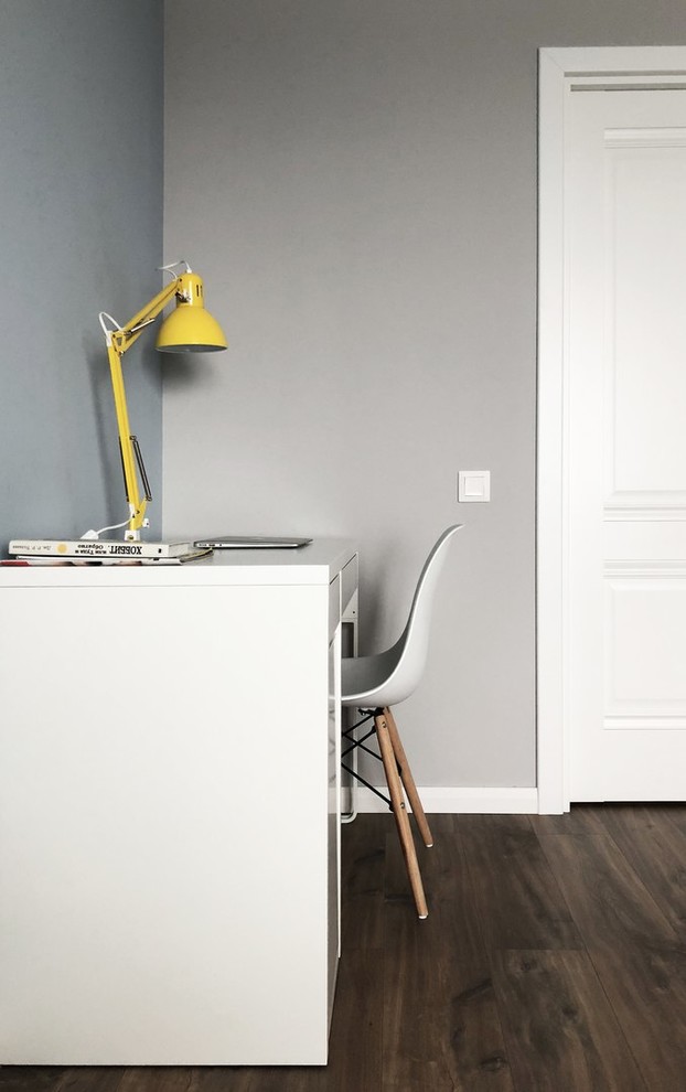 Medium sized scandi study in Moscow with grey walls, laminate floors, no fireplace, a freestanding desk and brown floors.