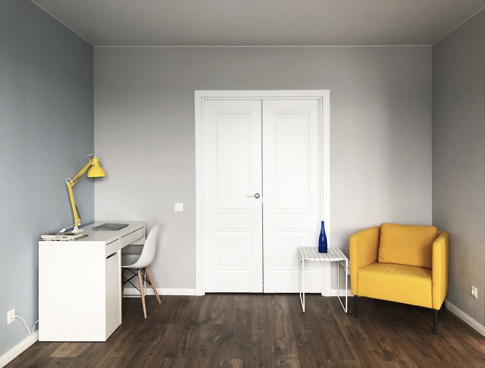 Immagine di un ufficio scandinavo di medie dimensioni con pareti grigie, pavimento in laminato, nessun camino, scrivania autoportante e pavimento marrone
