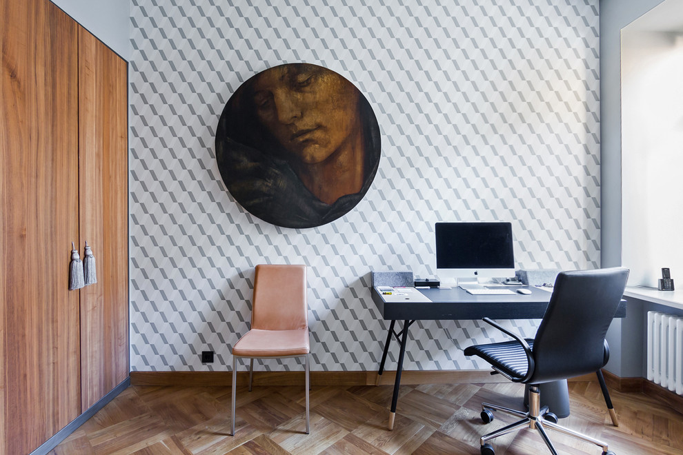 Cette photo montre un bureau tendance de taille moyenne avec un mur gris, un sol en bois brun et un bureau indépendant.