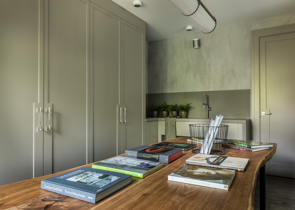 Großes Modernes Arbeitszimmer mit Studio, grüner Wandfarbe, braunem Holzboden, freistehendem Schreibtisch und grauem Boden in Moskau