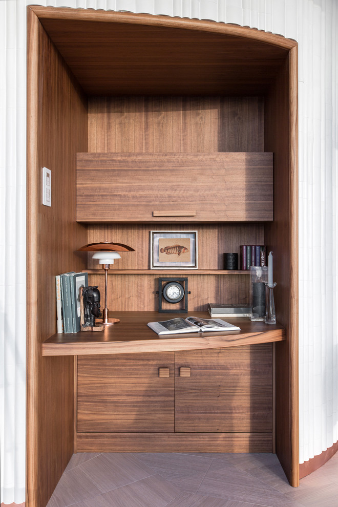 Foto di un piccolo ufficio minimal con scrivania incassata, pareti marroni e parquet chiaro