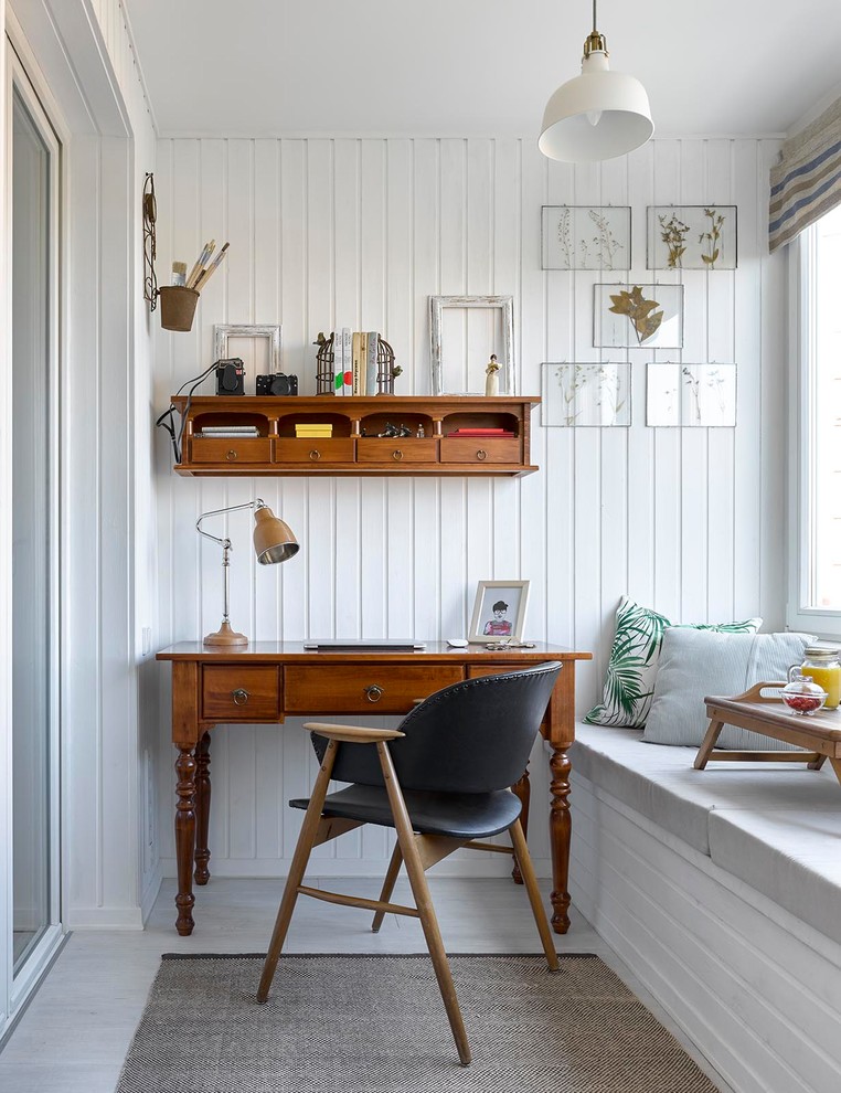 Идея дизайна: рабочее место в скандинавском стиле с белыми стенами, отдельно стоящим рабочим столом и серым полом