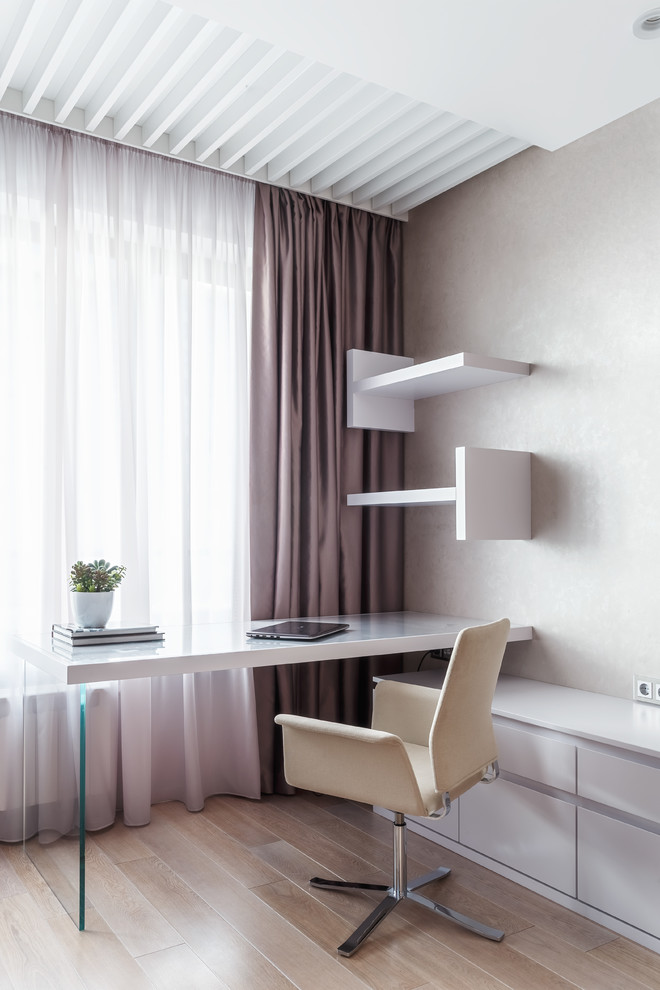 Idées déco pour un bureau contemporain avec un mur beige, un sol en bois brun, un bureau indépendant et un sol marron.