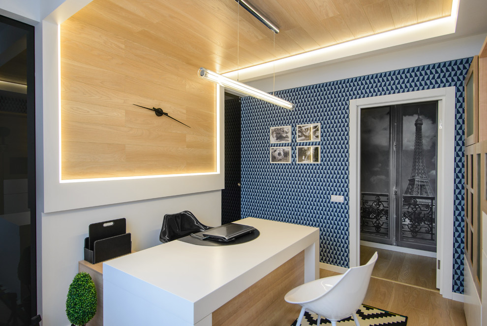 На фото: маленькое рабочее место в современном стиле с синими стенами, светлым паркетным полом и отдельно стоящим рабочим столом для на участке и в саду с