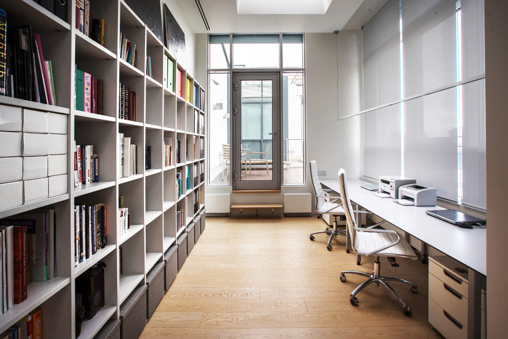 Esempio di un ufficio contemporaneo di medie dimensioni con pareti bianche, parquet chiaro e scrivania autoportante