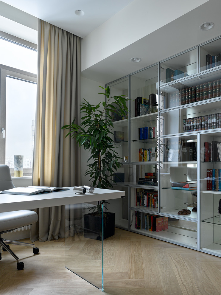 Immagine di uno studio design con pareti grigie, parquet chiaro, scrivania incassata, pavimento beige e libreria
