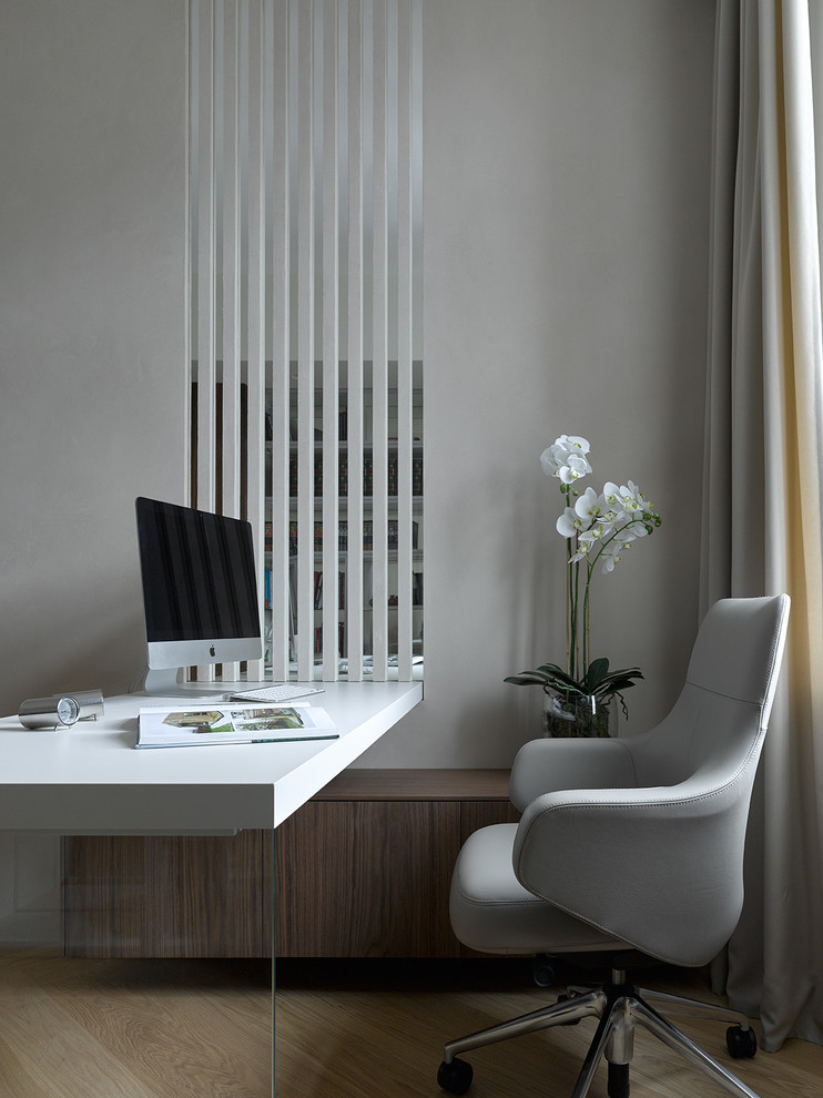 Immagine di un ufficio minimal con pareti grigie, parquet chiaro, scrivania incassata e pavimento beige