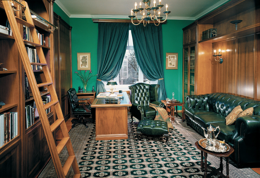 Exempel på ett klassiskt arbetsrum, med ett bibliotek, gröna väggar och ett fristående skrivbord