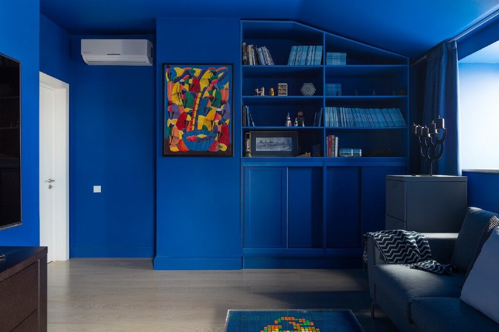 Источник вдохновения для домашнего уюта: домашняя библиотека в современном стиле с синими стенами, светлым паркетным полом и бежевым полом