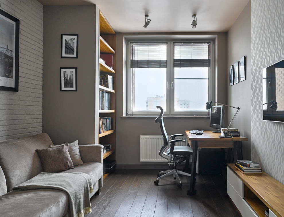 Kleines Modernes Arbeitszimmer mit Arbeitsplatz, grauer Wandfarbe, dunklem Holzboden und freistehendem Schreibtisch in Moskau