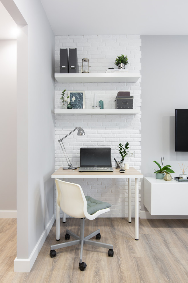 Imagen de despacho contemporáneo pequeño con paredes grises, suelo laminado, escritorio independiente y suelo beige