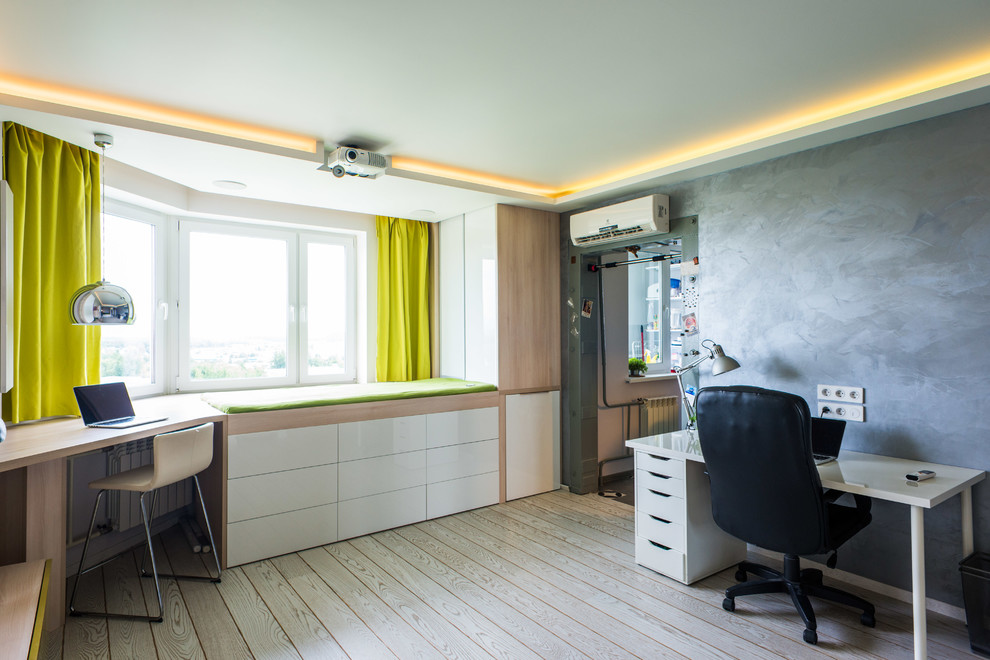 Modernes Arbeitszimmer ohne Kamin mit Arbeitsplatz, grauer Wandfarbe und hellem Holzboden in Moskau