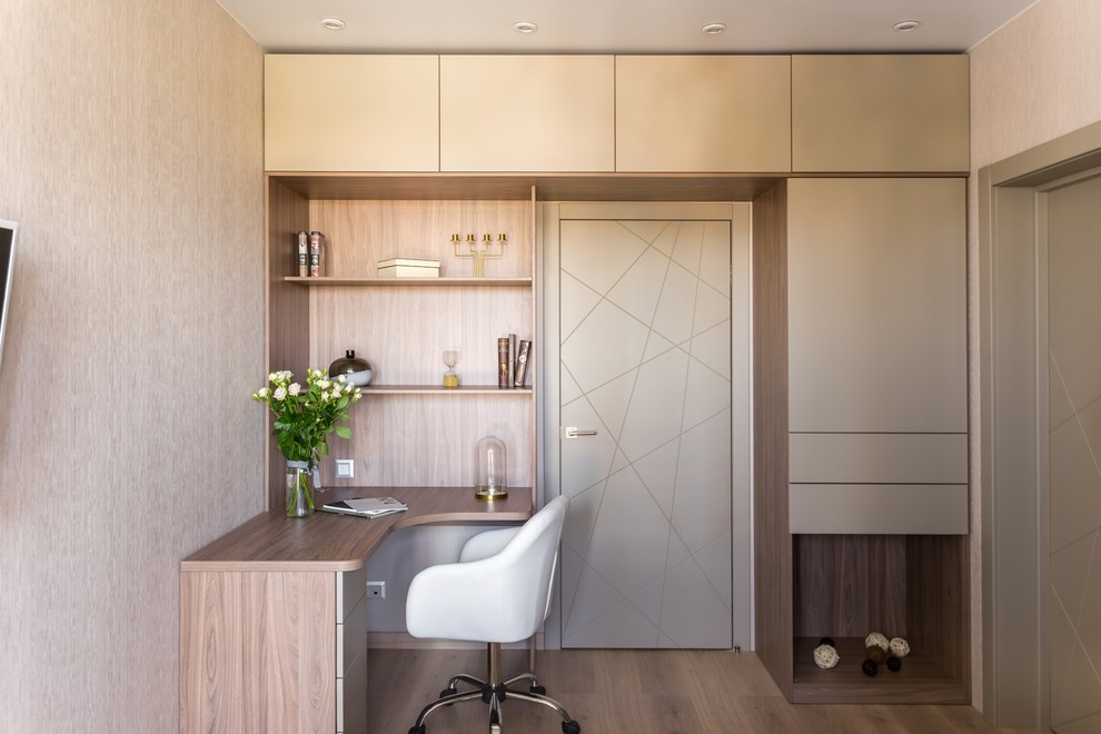 Contemporary home office in Moscow with beige walls, medium hardwood flooring, a built-in desk and brown floors.