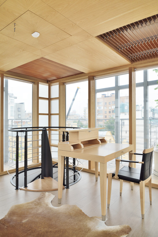 Esempio di un ufficio minimal di medie dimensioni con pareti beige, parquet chiaro, scrivania autoportante e pavimento beige