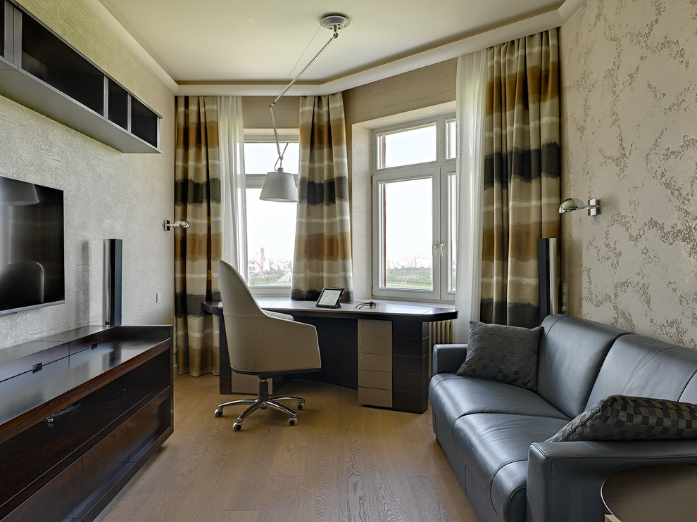 Imagen de despacho contemporáneo con paredes beige, suelo de madera clara, escritorio independiente y suelo beige