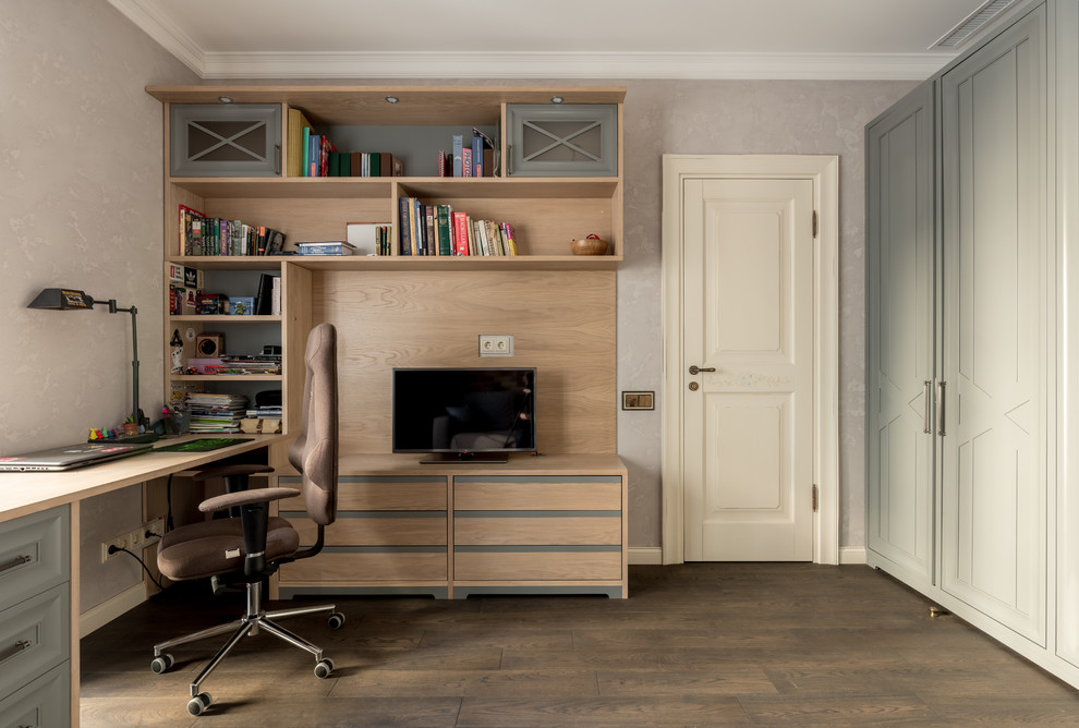 Cette image montre un bureau traditionnel avec un mur beige, parquet foncé, un bureau intégré et un sol marron.