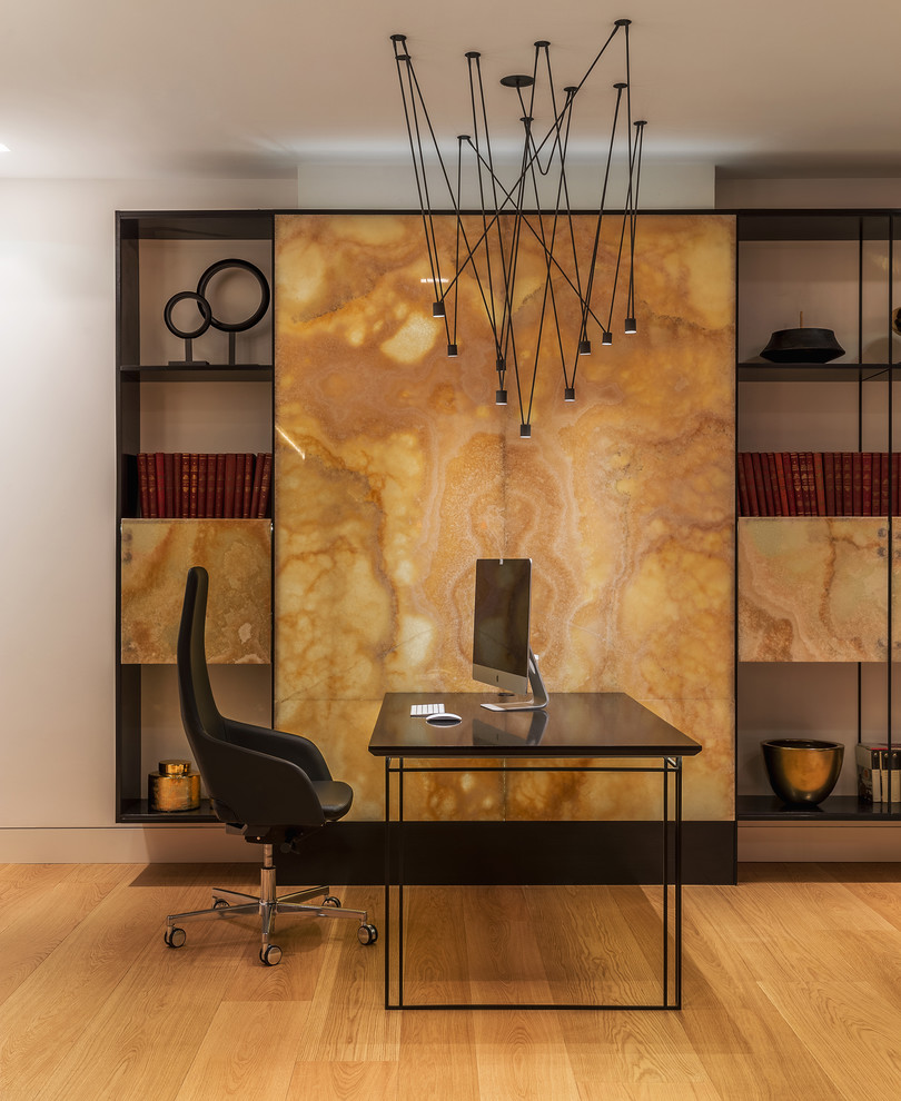 Imagen de despacho actual con paredes blancas, suelo de madera clara y escritorio independiente