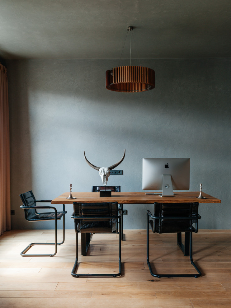Cette image montre un bureau urbain avec un mur gris, un sol en bois brun, un bureau indépendant et un sol marron.