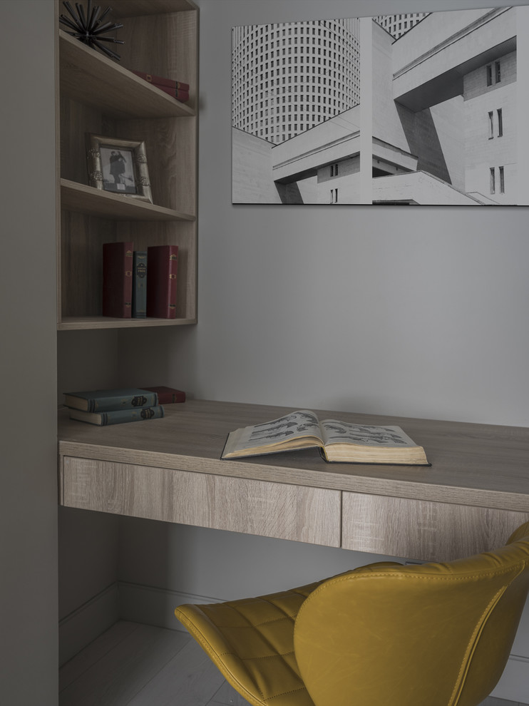 Стильный дизайн: кабинет в современном стиле с серыми стенами и встроенным рабочим столом - последний тренд