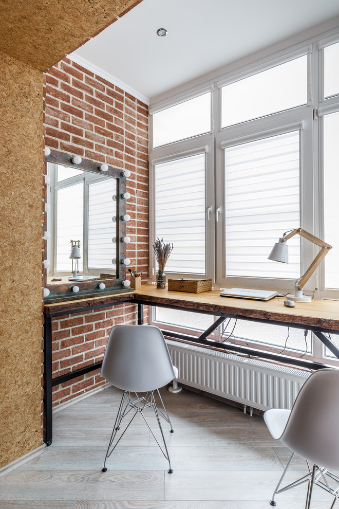 Stilmix Arbeitszimmer mit Arbeitsplatz, roter Wandfarbe, freistehendem Schreibtisch und grauem Boden in Sonstige