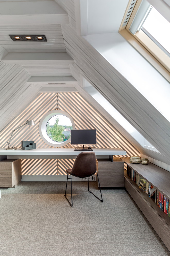 Idéer för mellanstora funkis hemmabibliotek, med heltäckningsmatta, grått golv, ett inbyggt skrivbord och vita väggar