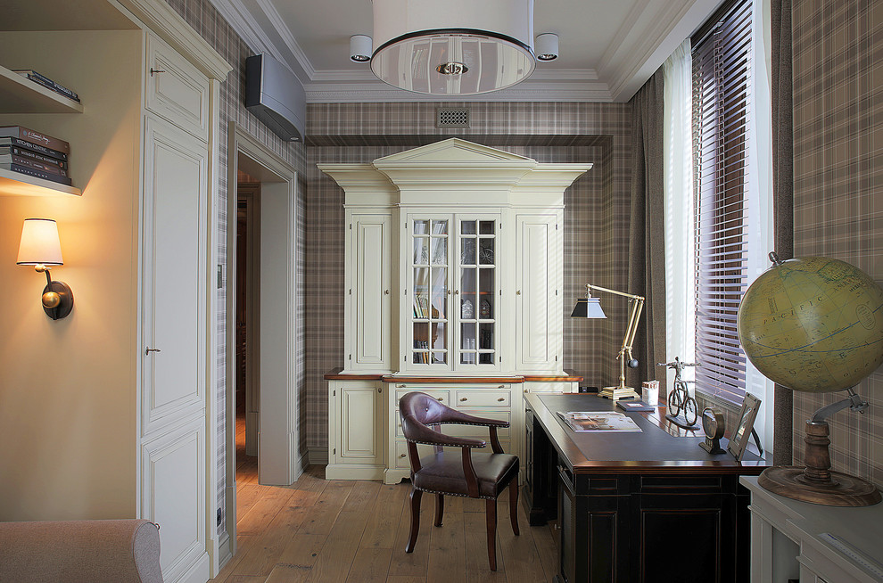 Diseño de despacho tradicional con paredes marrones, suelo de madera en tonos medios y escritorio independiente